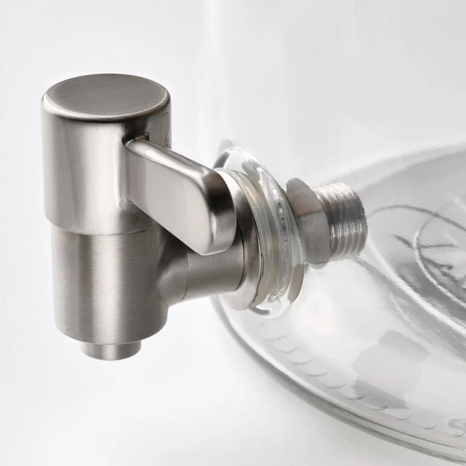Clear glass jar with metal spigot, high quality finish, designed for beverages.