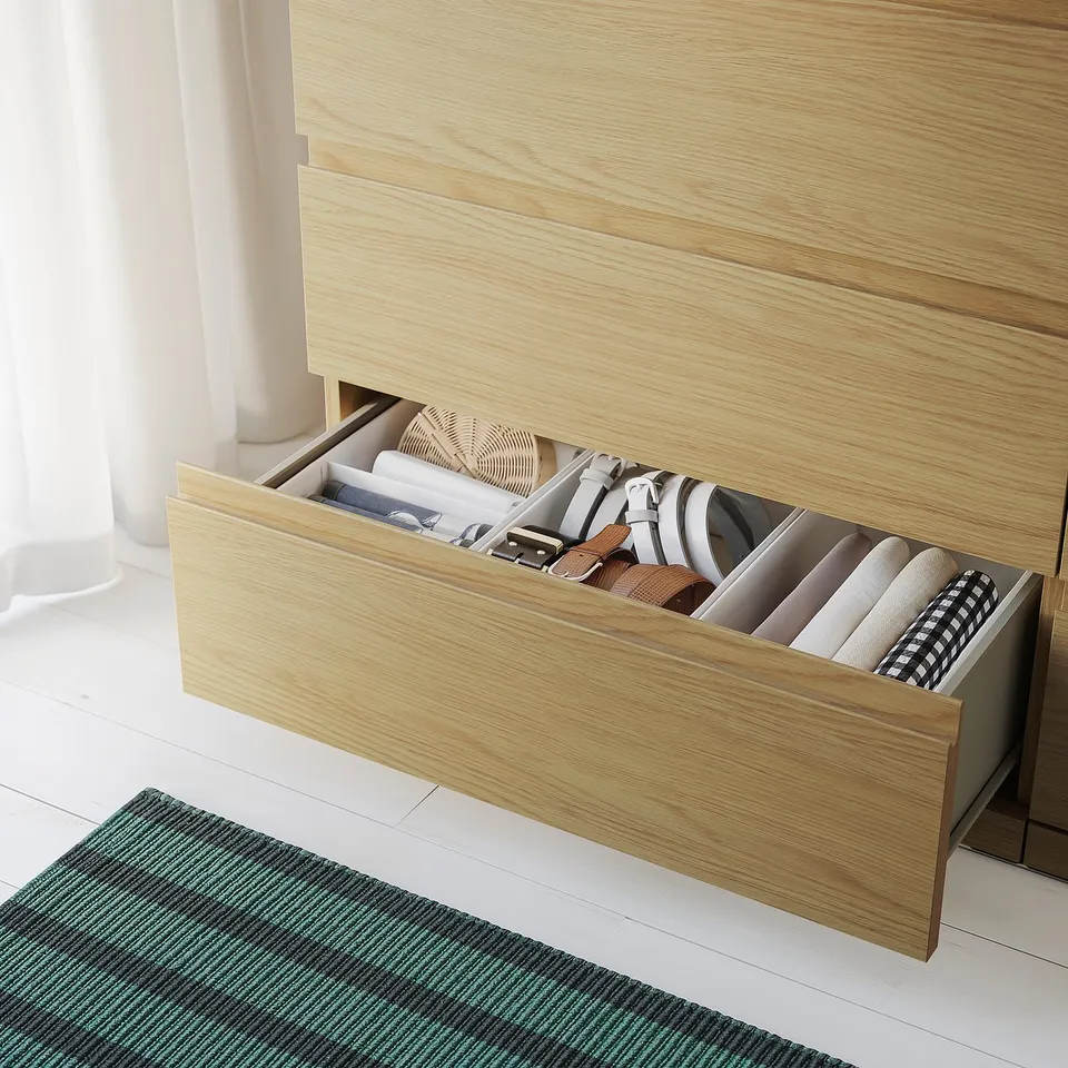 A light wood drawer set with multiple compartments neatly storing assorted items, showcasing organised storage capability.