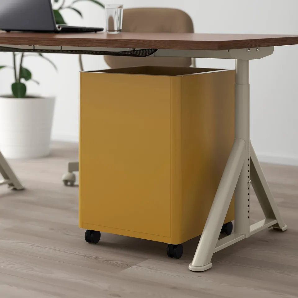 A yellow office drawer unit on wheels under a desk, featuring silent-closing drawers.