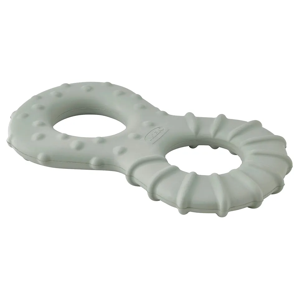 A mint green UTSÅDD dog toy made of natural rubber. It has a unique, interlocking ring shape with textured surfaces for chewing and hiding treats.