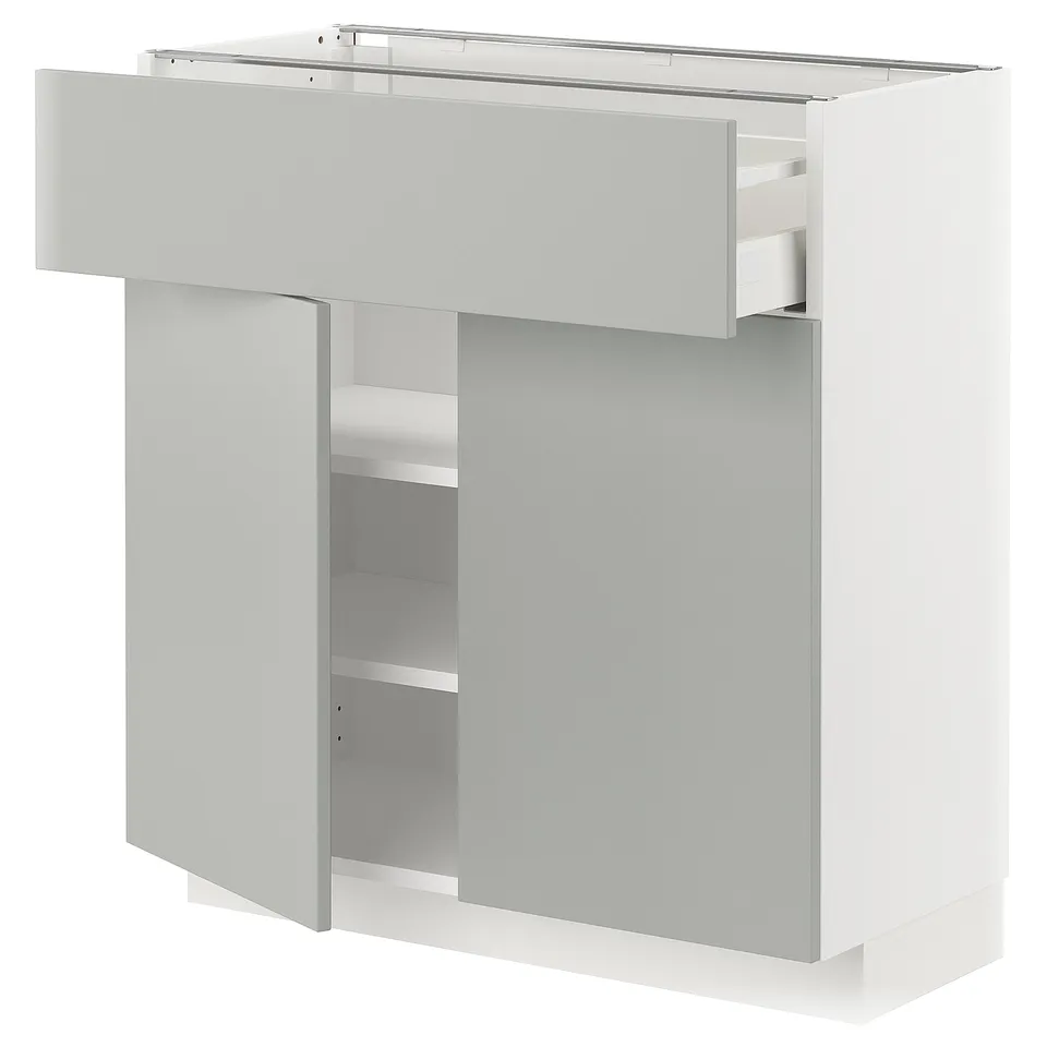 Light grey METOD kitchen cabinet, modern design, white finish, rectangular shape with drawer and shelves.