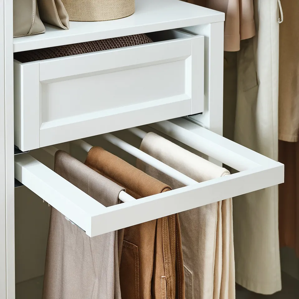 White trouser drawer organizer by ikea in wardrobe, holds rolled pants neatly.