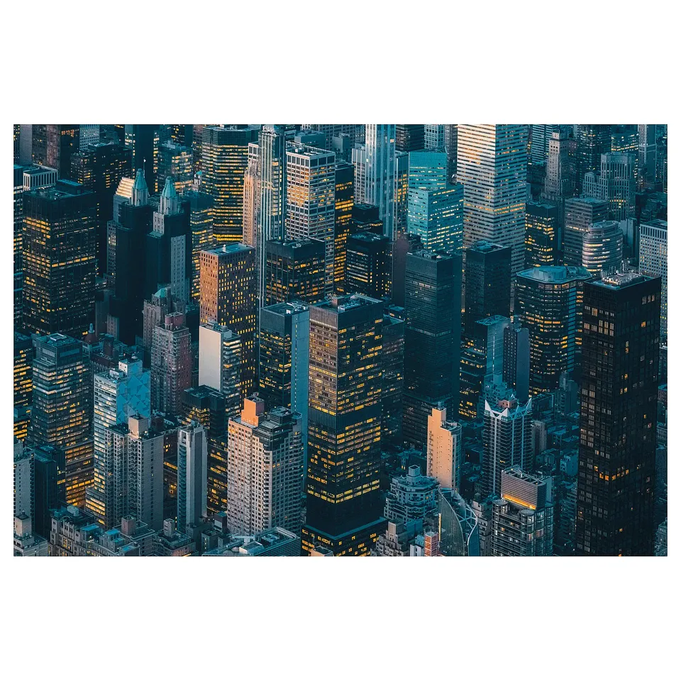 City skyline poster at night with illuminated buildings. Dense, varied, and high-rise structures in dark blue tones.