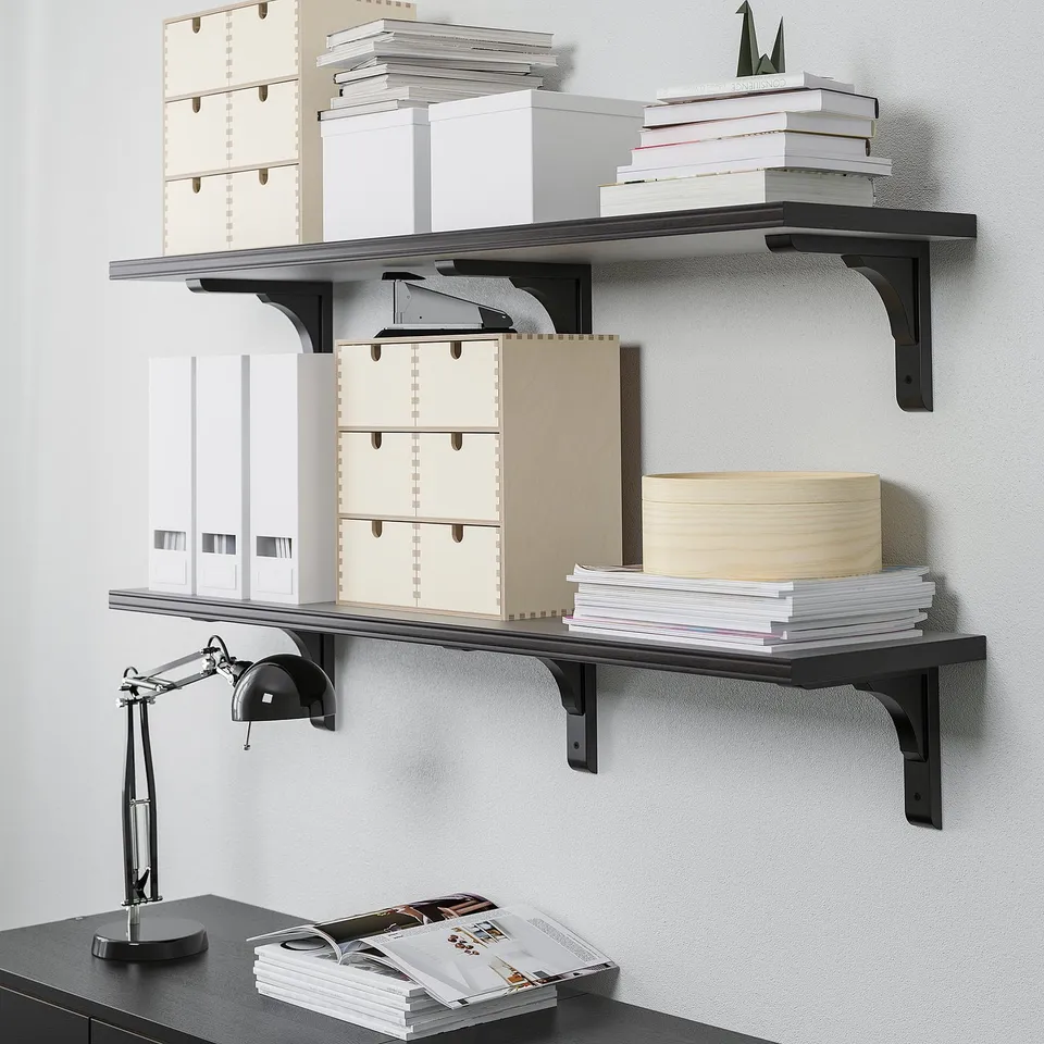 Wall shelves with books and boxes, showcasing organisational storage. A desk lamp on the shelf below, illustrating a functional workspace setup.