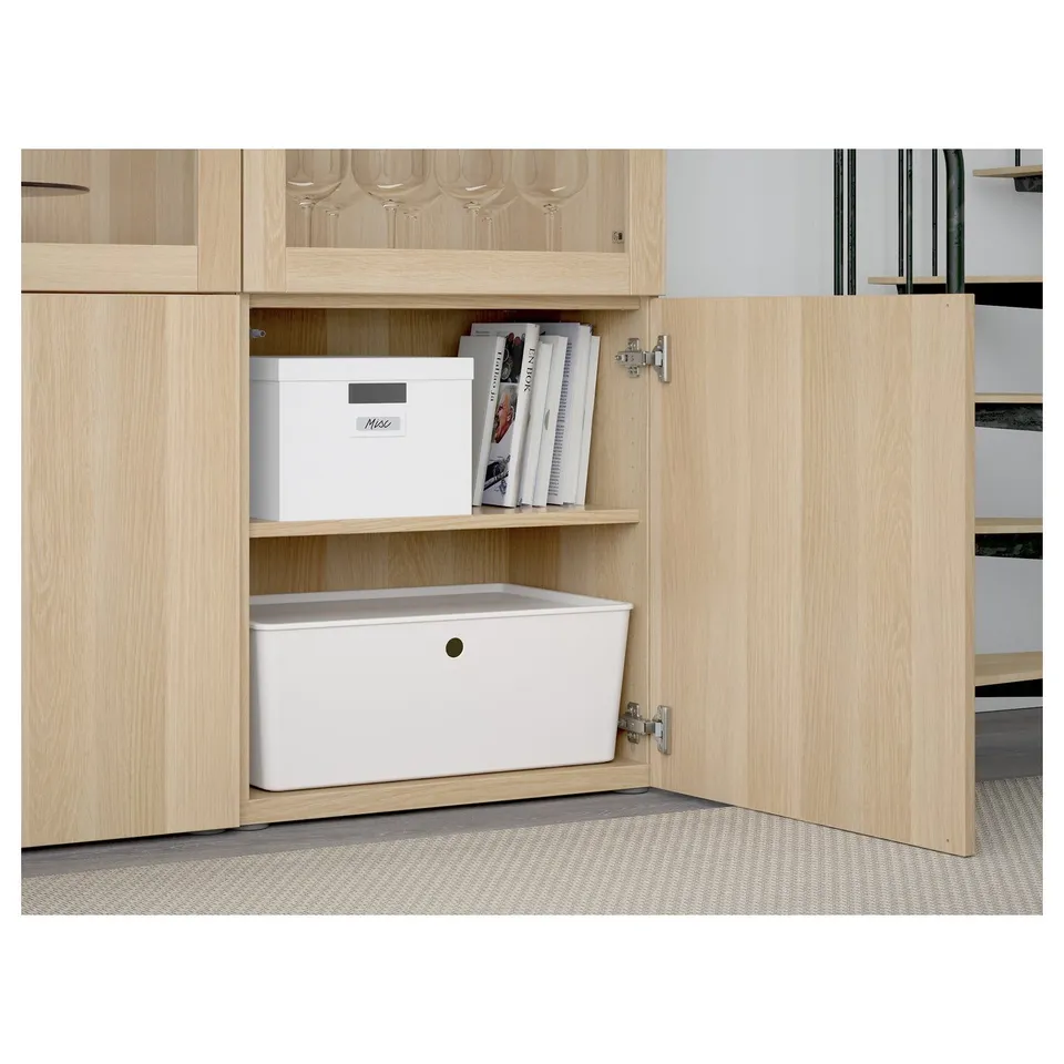 Light wood cabinet with glass door storage. Opened door reveals organised boxes and shelves.