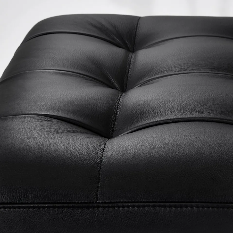 Close-up of black leather chair, showcasing intricate stitching and high-quality material.