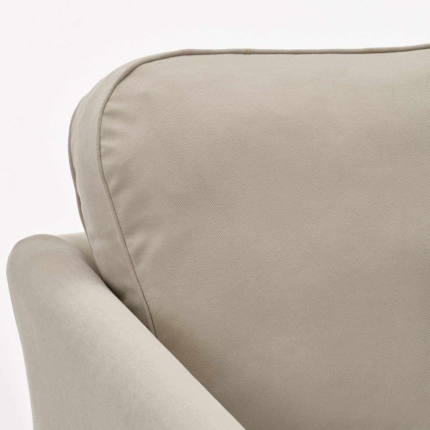 Beige upholstered sofa corner with soft, smooth fabric and supportive cushions.