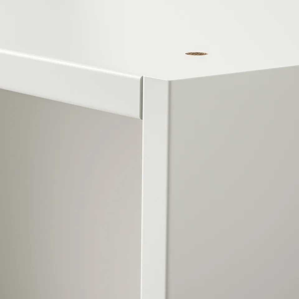 Clean, white corner of modern room with precise, smooth surfaces and recessed lighting.
