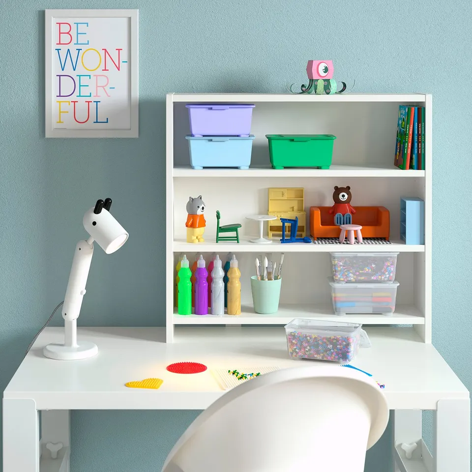 Childs desk setup with white PÅHL desk, colourful storage bins, toys, and a motivational poster.