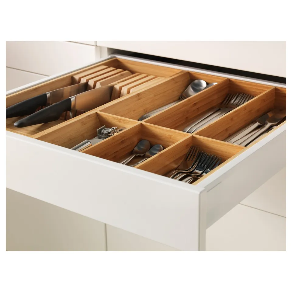 Bamboo drawer organiser for kitchen utensils, made from wood, stores knives, spoons, and forks in separate compartments.