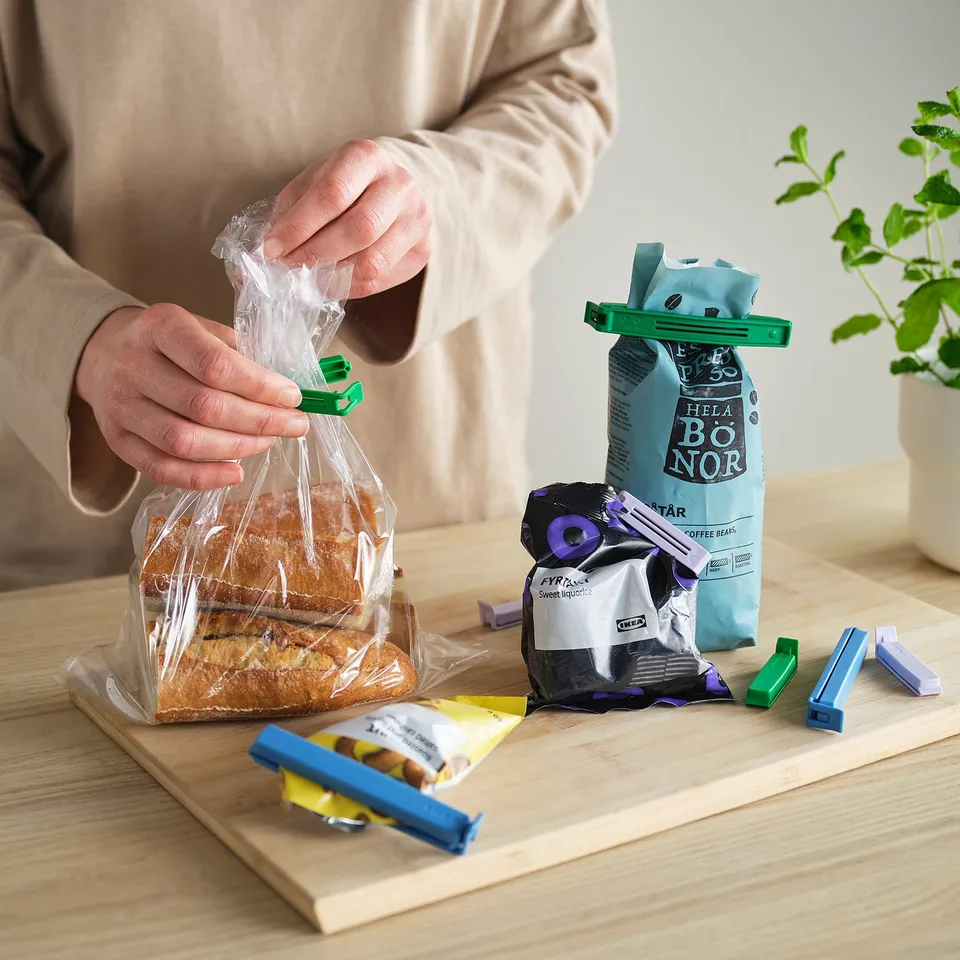 Sealing bread with BEVARA clips. Four clips and food on table.