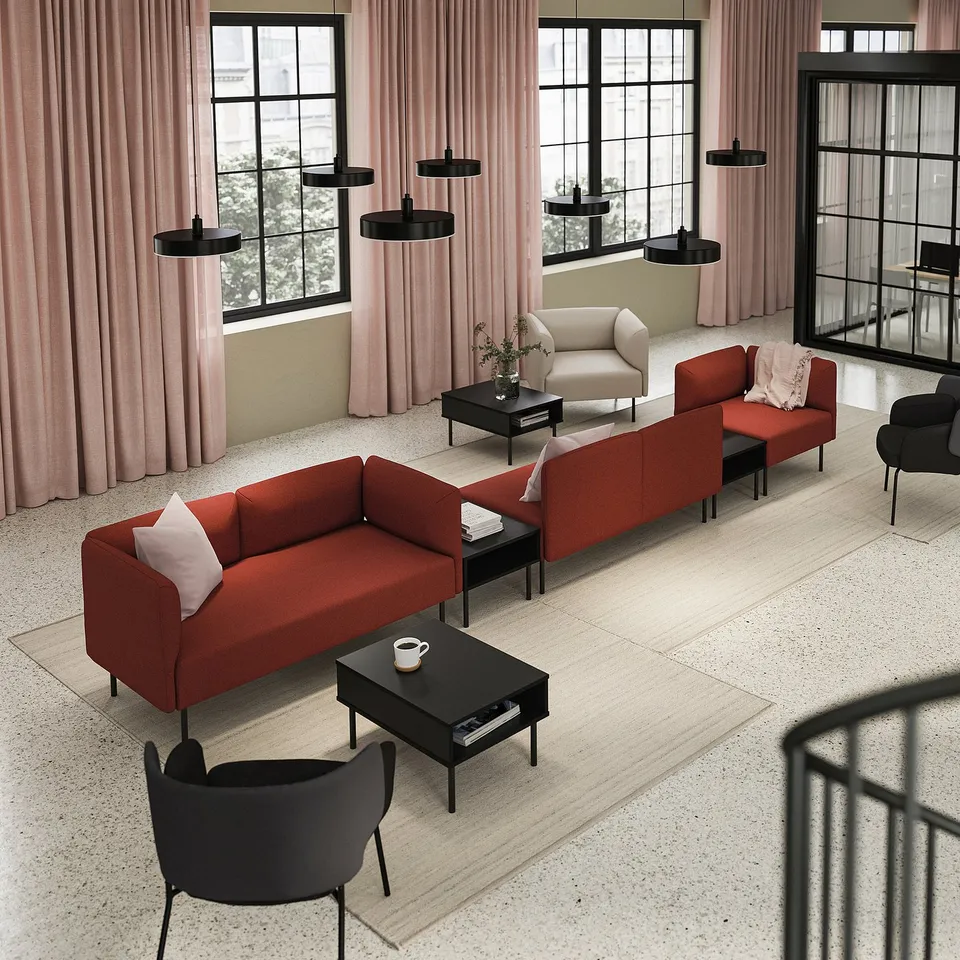 Modern living room with red sofa, black tables, pink curtains, and hanging lamps.