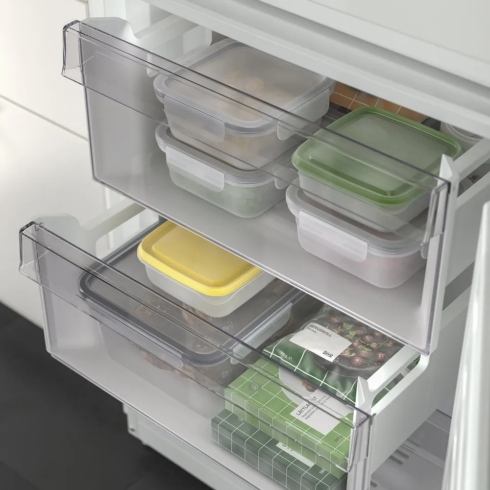 Fridge door with adjustable bins holding various food containers, demonstrating flexible storage.