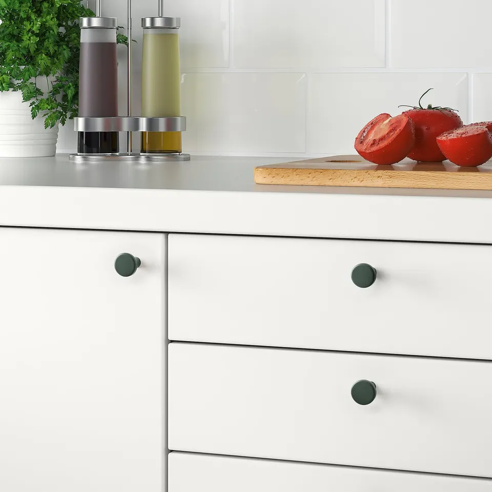 Modern kitchen with white cabinets & teal BAGGANÄS knobs. Small, round, smooth, & stylish.