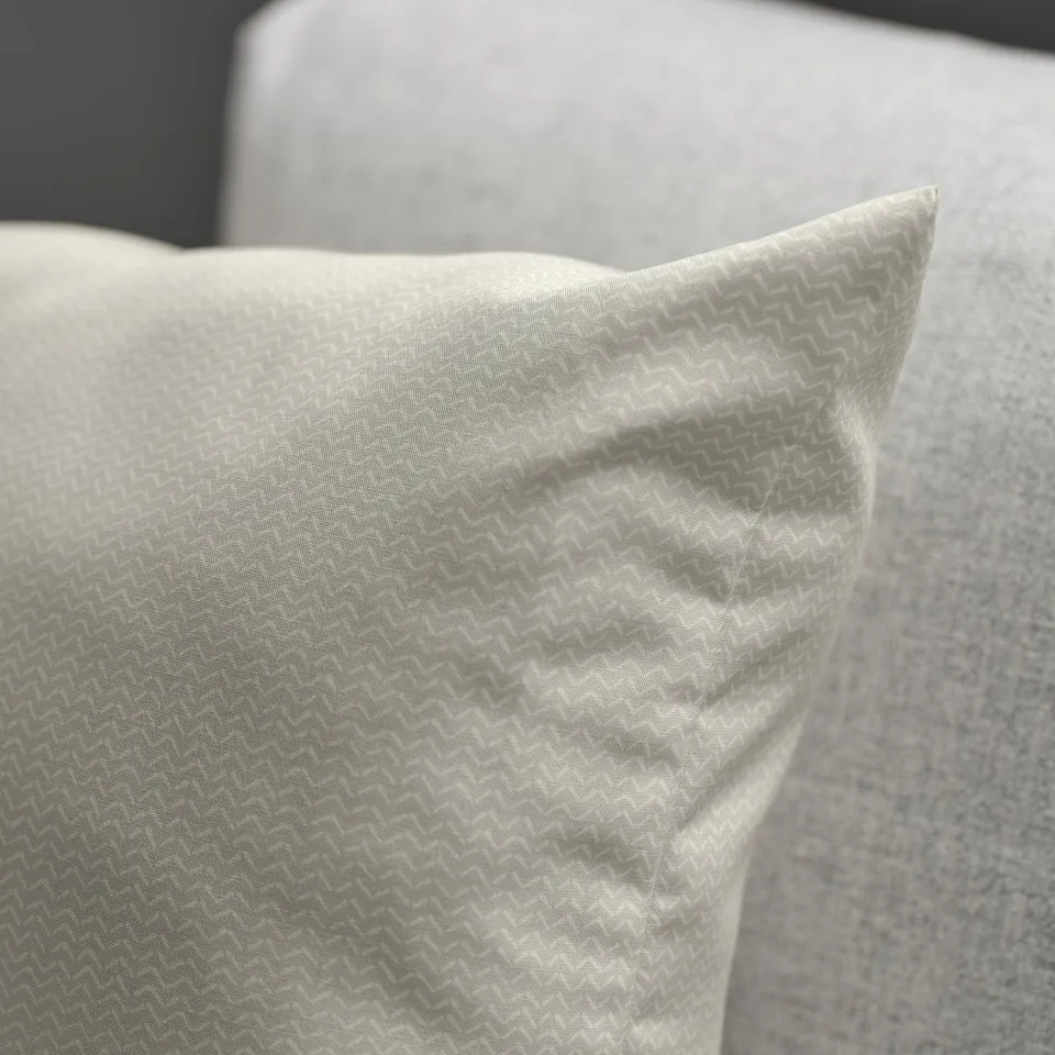 Light beige cushion with subtle pattern, soft texture, and delicate sheen. Perfect for cosy comfort.