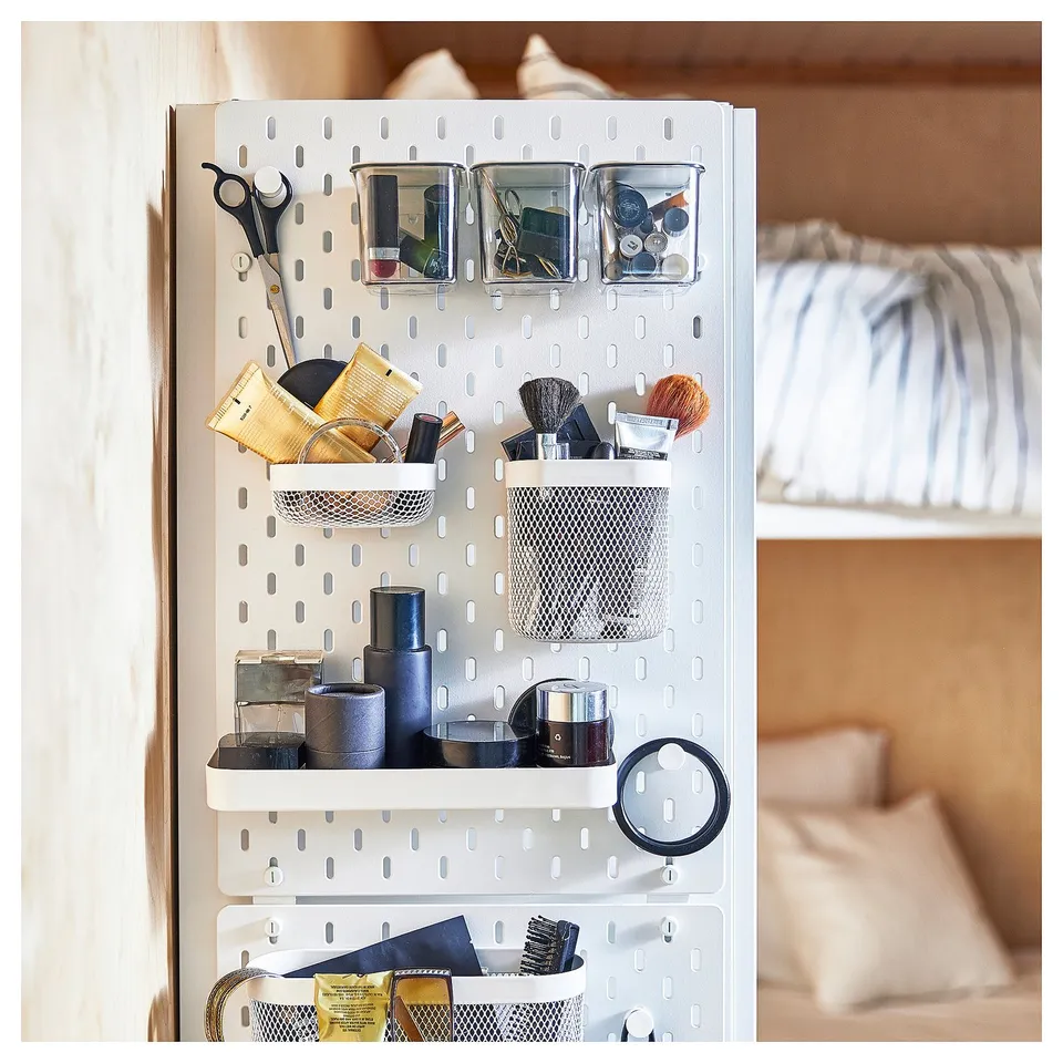 Organised white SKÅDIS pegboard with containers and tools.