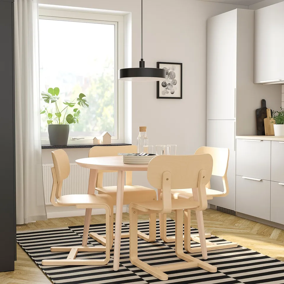 Minimalist dining set with 4 chairs, round, near window.
