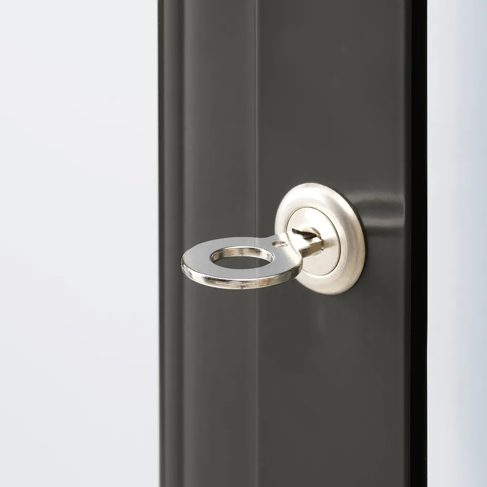 Close-up of metal key lock on dark grey metal surface. High-quality, sleek design.