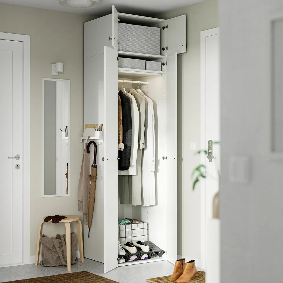 A tall white LASTARE wardrobe combo storing clothes, linens, and shoes. Its designed for small spaces, maximising wall height for efficient storage.