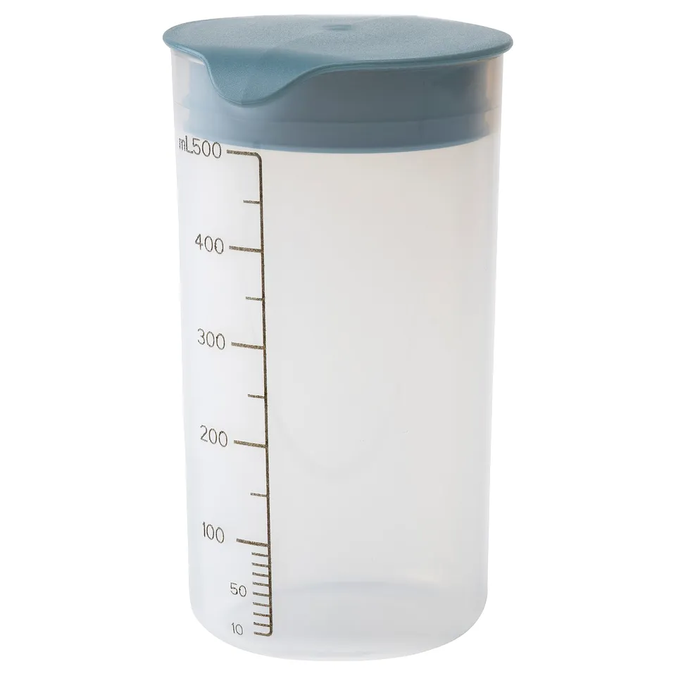 A clear plastic container with teal lid, marked with measurement lines, used for mixing and storing shakes or batters.