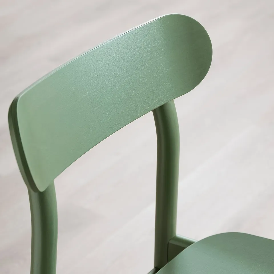 Close-up of a modern green chair showcasing its strong wooden backrest and smooth finish.