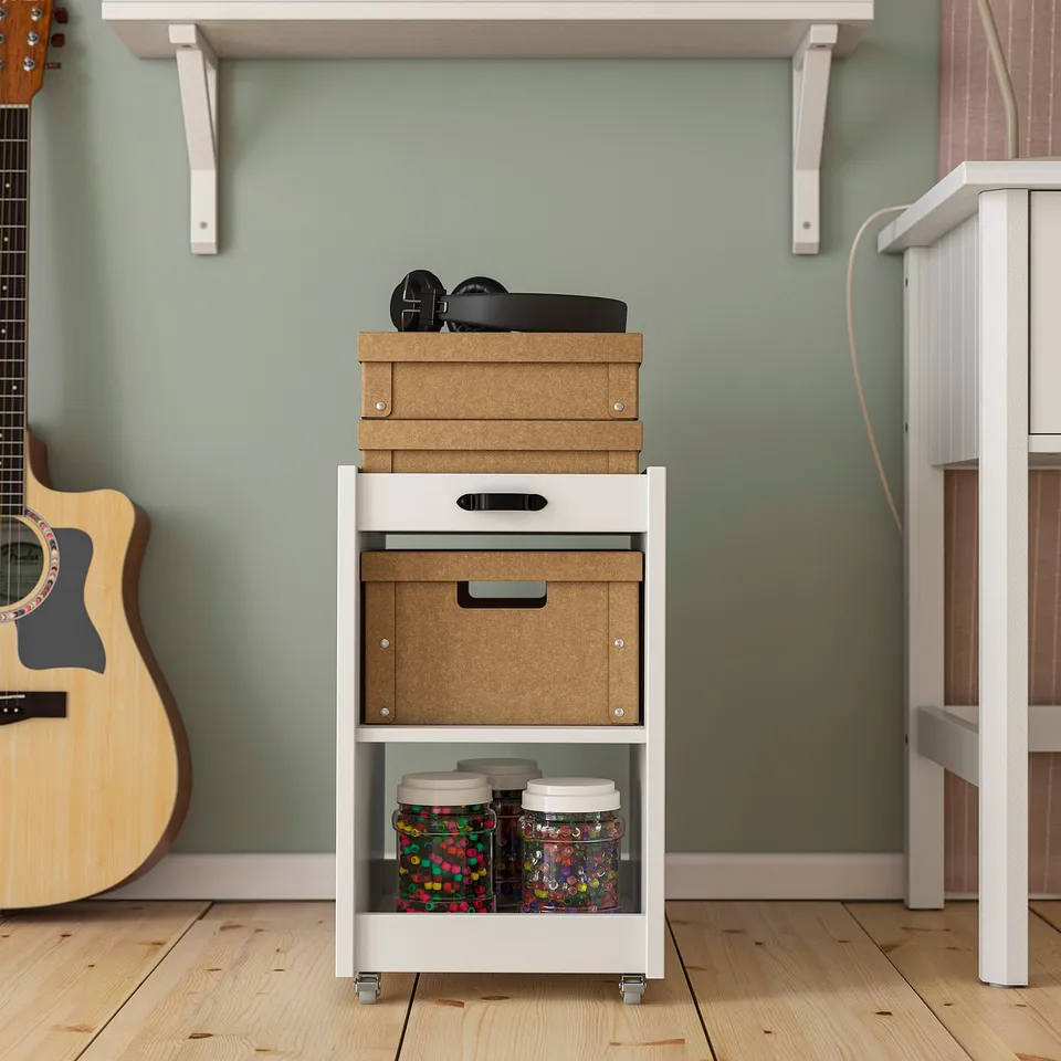 Small storage trolley with wheels, holding boxes and jars. Perfect for organising and moving workspace items.