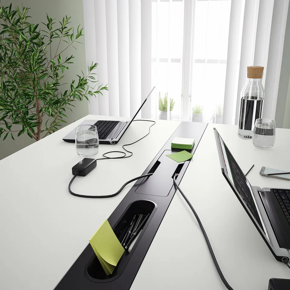 Modern conference table with integrated cable management and footrest for comfort; ideal for meetings or work sessions.