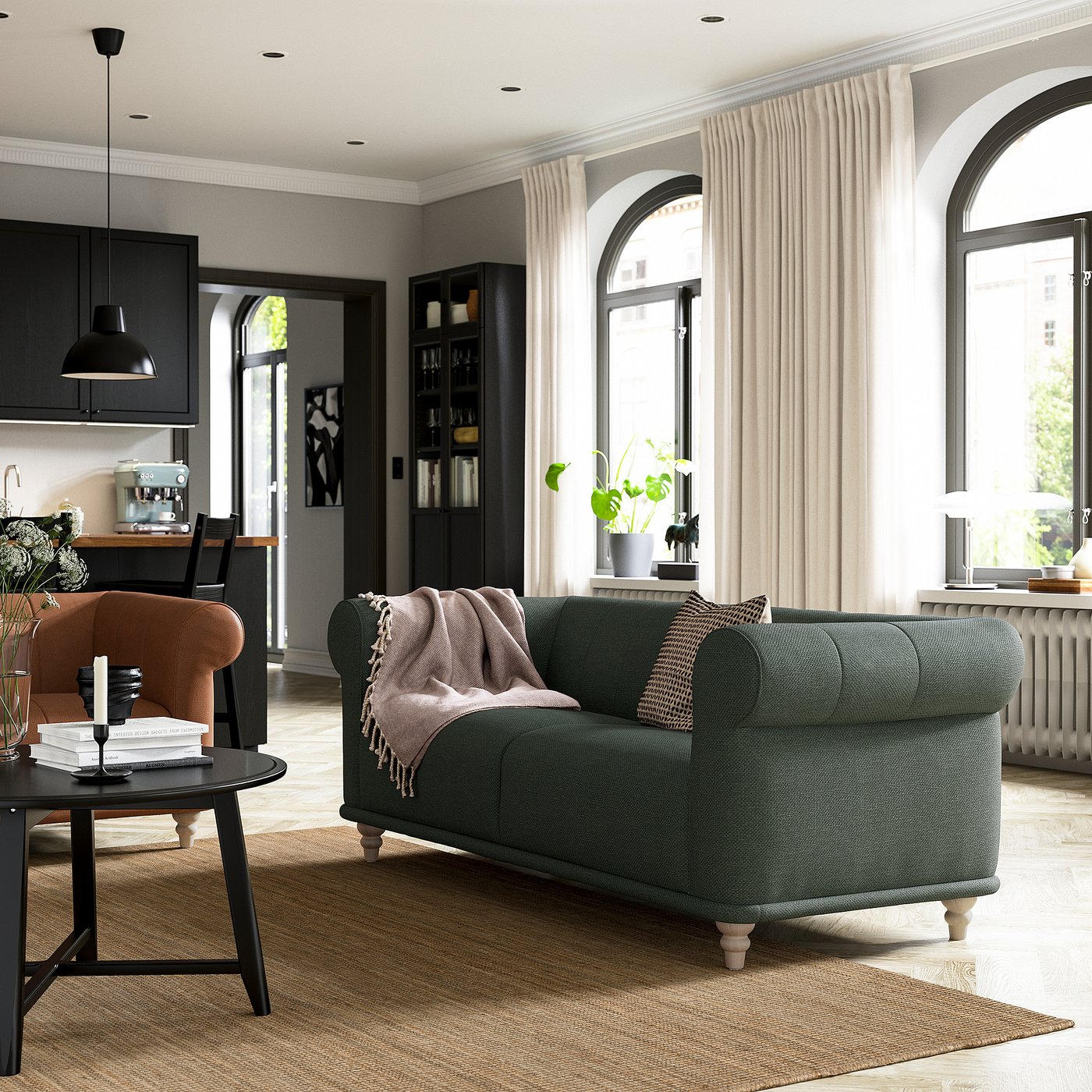 Cosy living room with VISKAFORS dark green sofa, beige armchair, black coffee table, arched windows, and light floor.