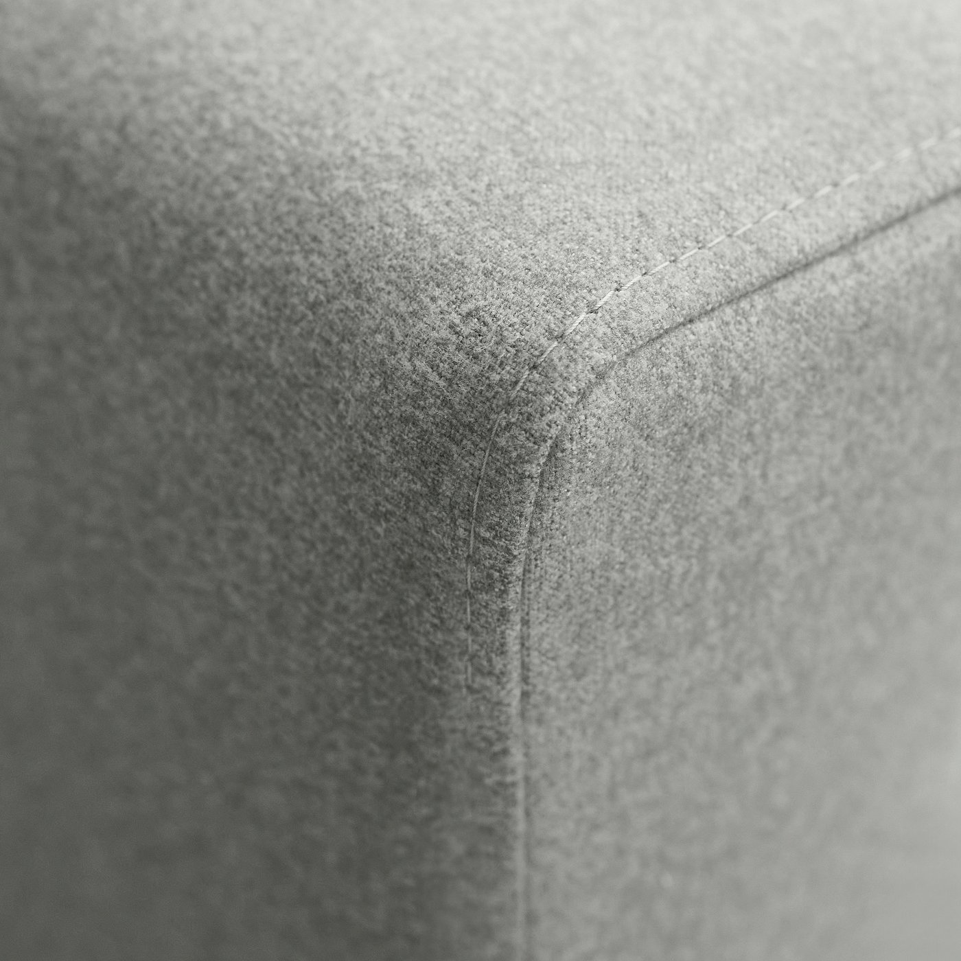 Close-up of upholstered sofa corner, showcasing high-quality stitching and texture.