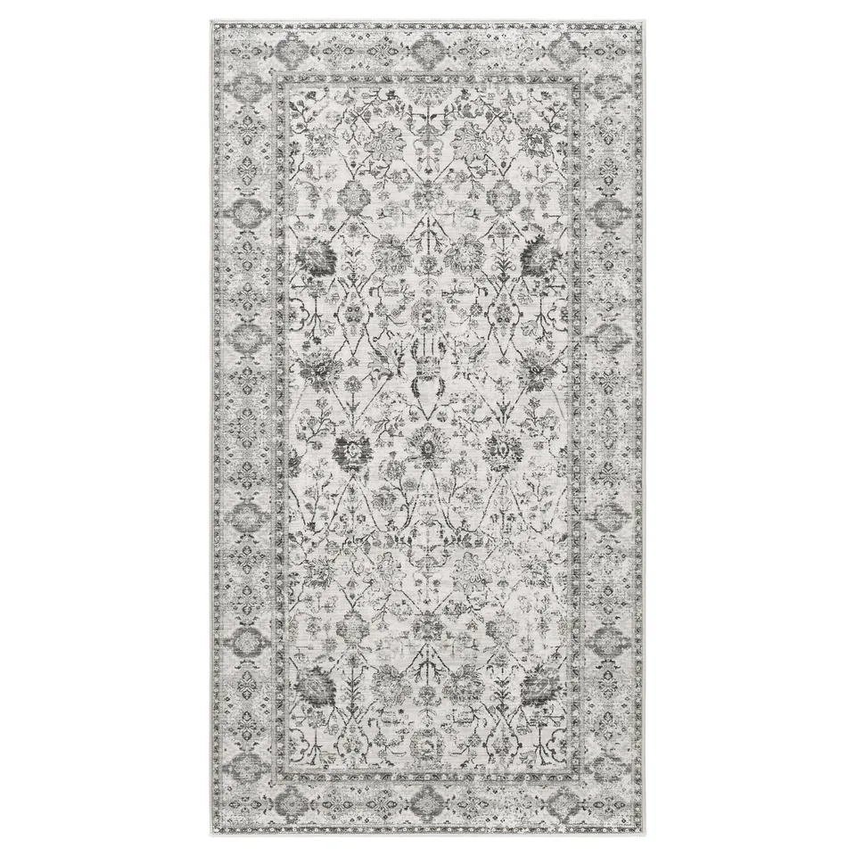 A grey LOKALTÅG rectangular rug with an ornate floral pattern. Its made from recycled polyester and synthetic rubber.