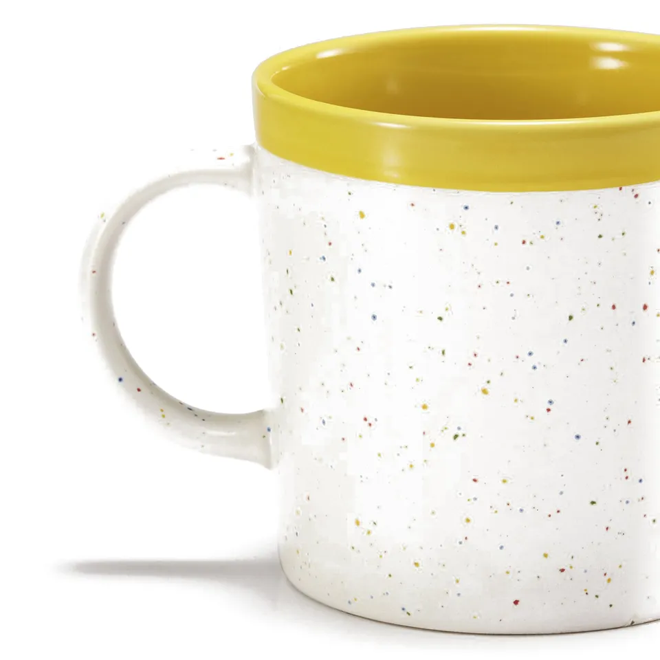 Handcrafted mug with speckled white body, vibrant yellow rim & handle, offering a stylish and secure grip.