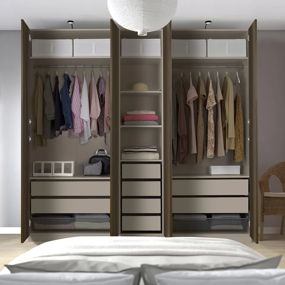 Open wardrobe with clothes, drawers, and storage boxes. Integrated hangers and shelves for organised storage.