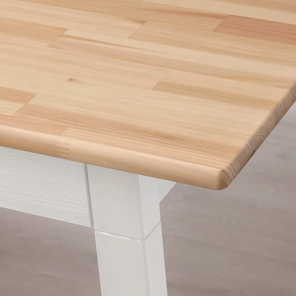A close-up of a smooth, polished wooden tabletop supported by sturdy white metal legs, showcasing a modern, sleek design.