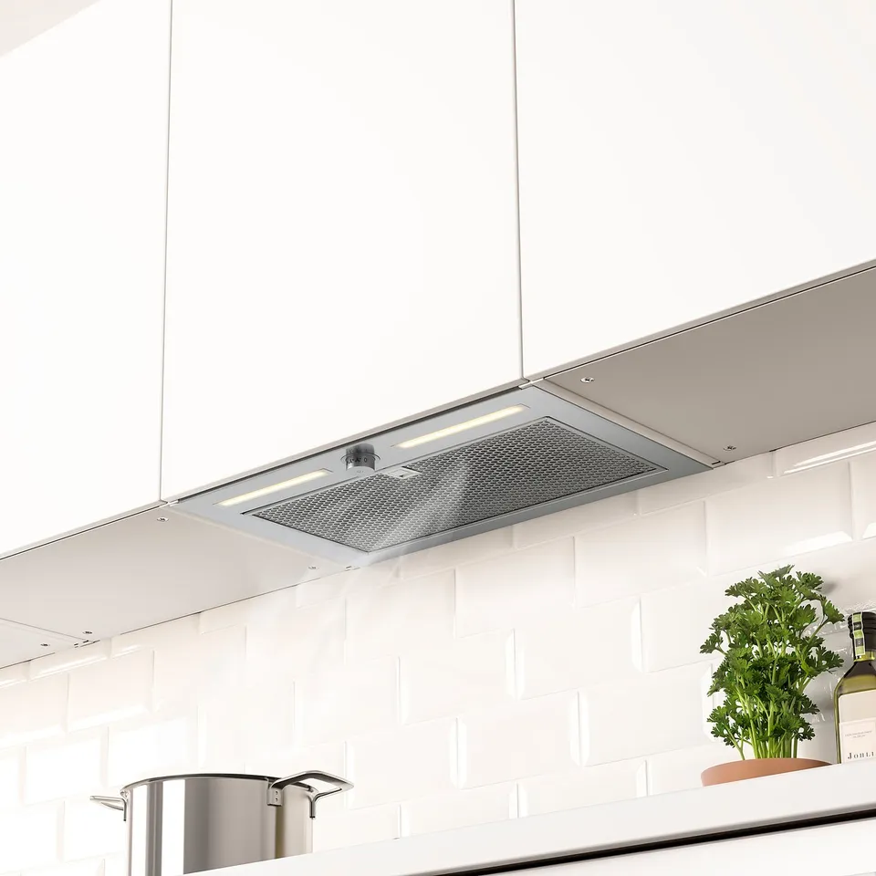 Modern kitchen with hidden range hood, led lighting, and herbs on counter.