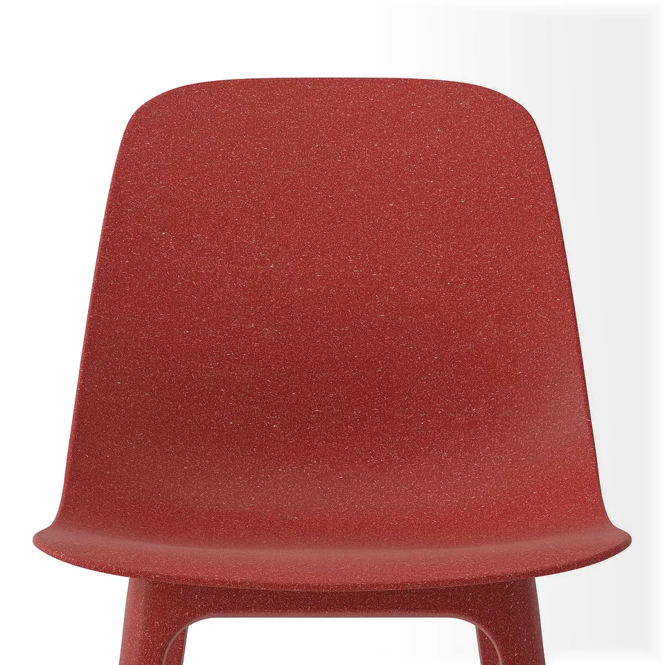 Red upholstered chair, smooth texture, ergonomic design.