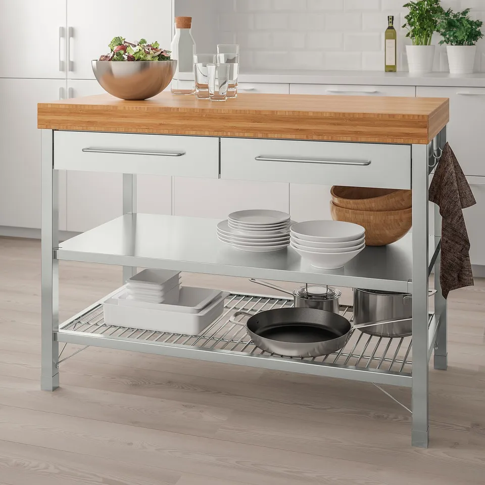 Grey & bamboo RIMFORSA kitchen island with storage drawers, shelves, metal frame, salad bowl, glasses, & organised dishes.