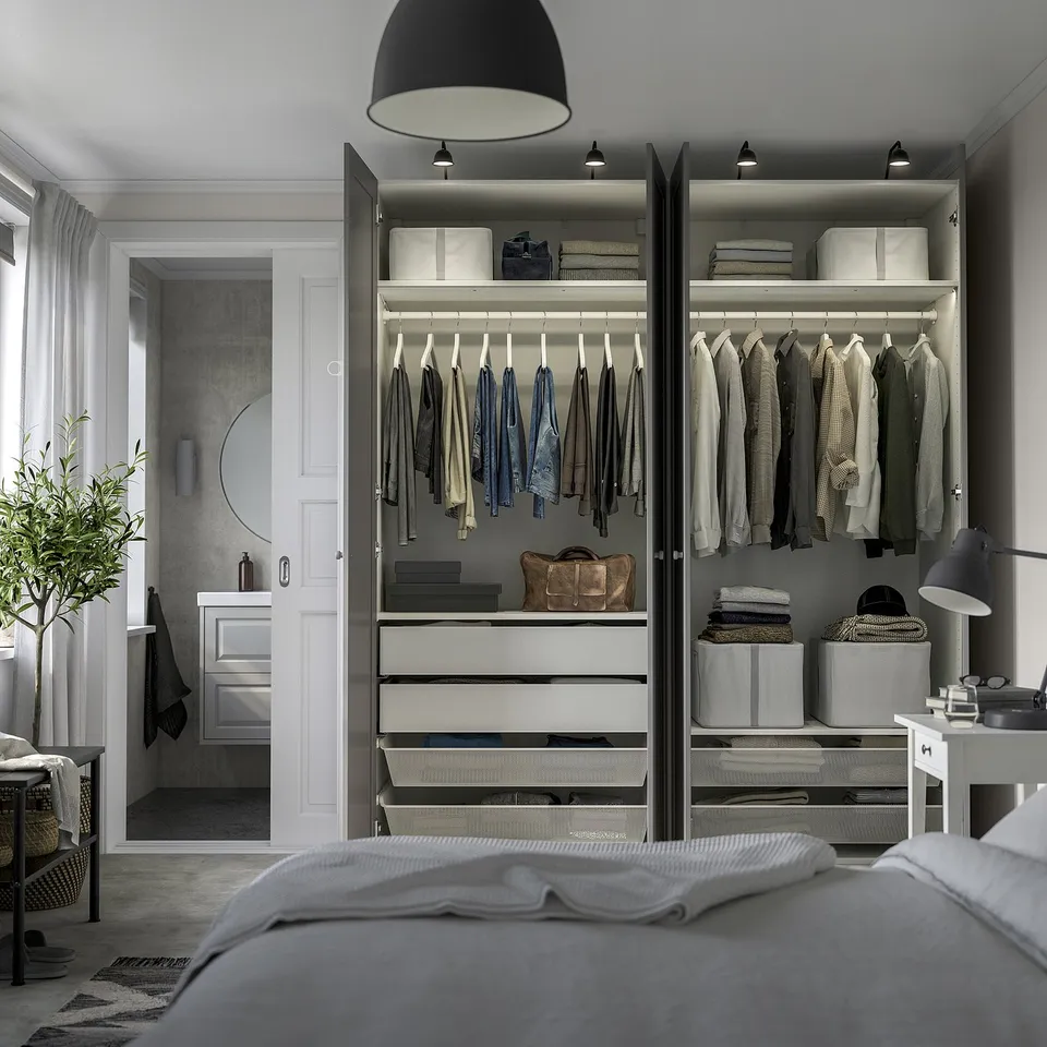 Elegant bedroom with open wardrobe, showcasing clothes storage, shelving, and integrated lighting.
