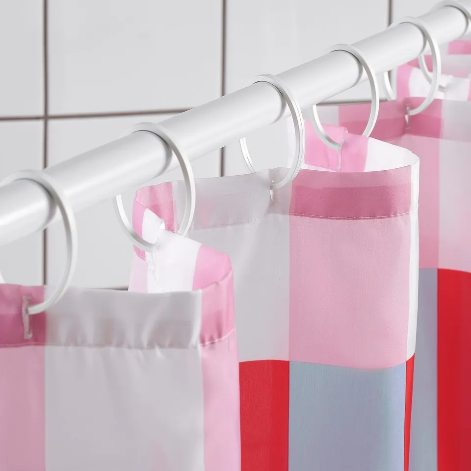 A shower curtain with colourful blocks, featuring white, pink, red, and grey stripes. The water-repellent fabric keeps the curtain dry.