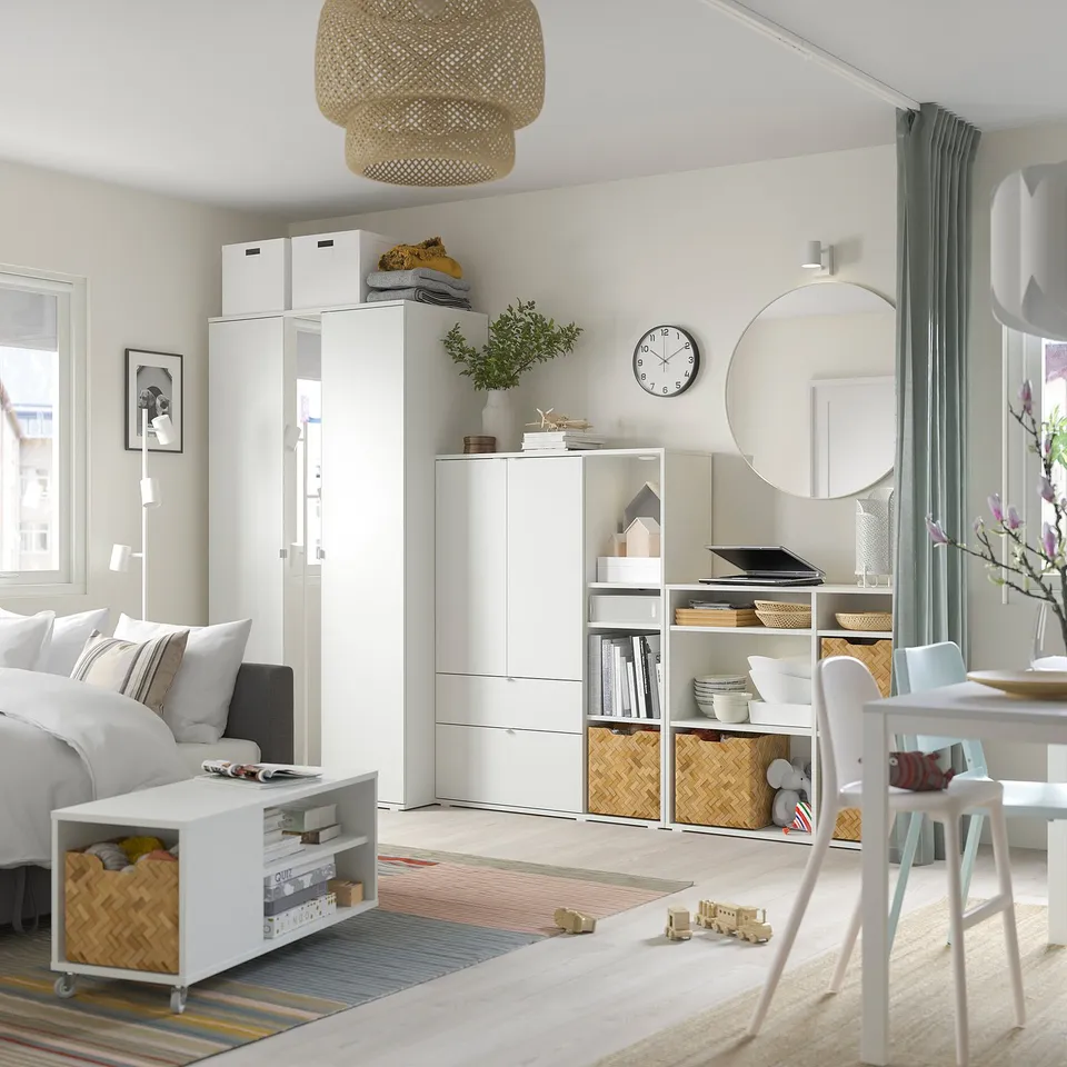 Modern kids room with white VIHALS storage, grey rug, wooden toys, and grey curtains.