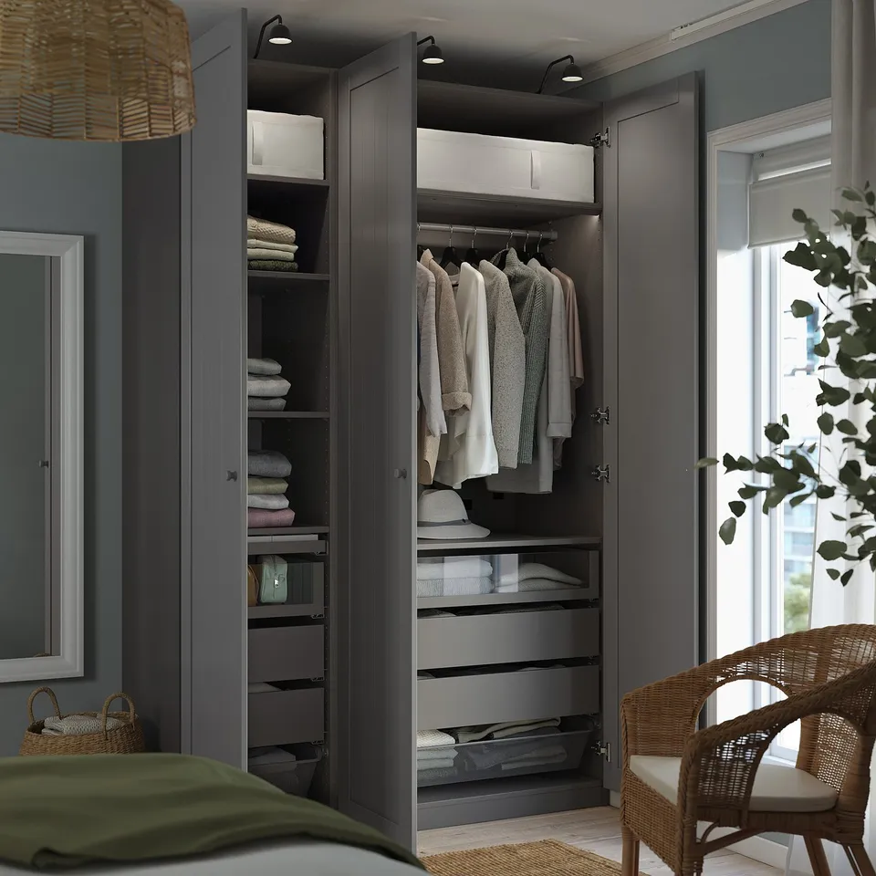 Modern wardrobe with open clothes, hangers, and shelves. Integrated lighting highlights the organised storage.