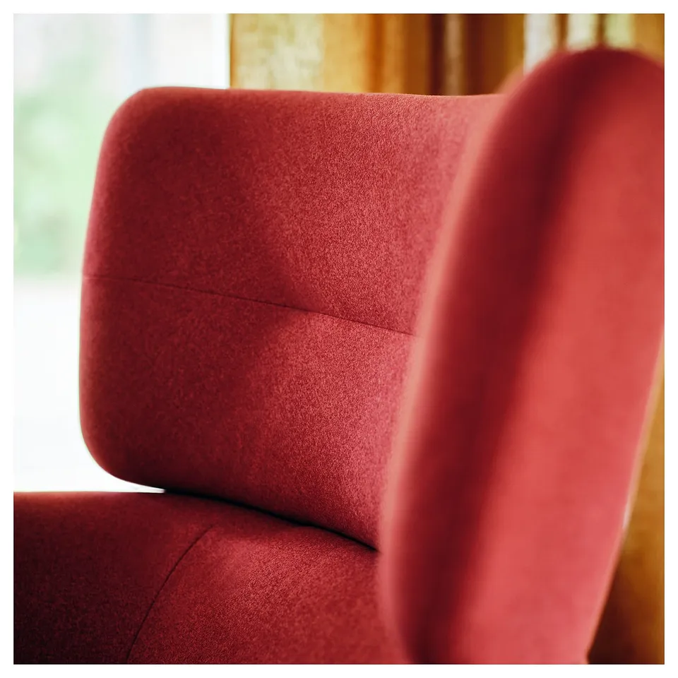 Soft red wing chair close-up. Plush, pattern fabric. Invites relaxation.