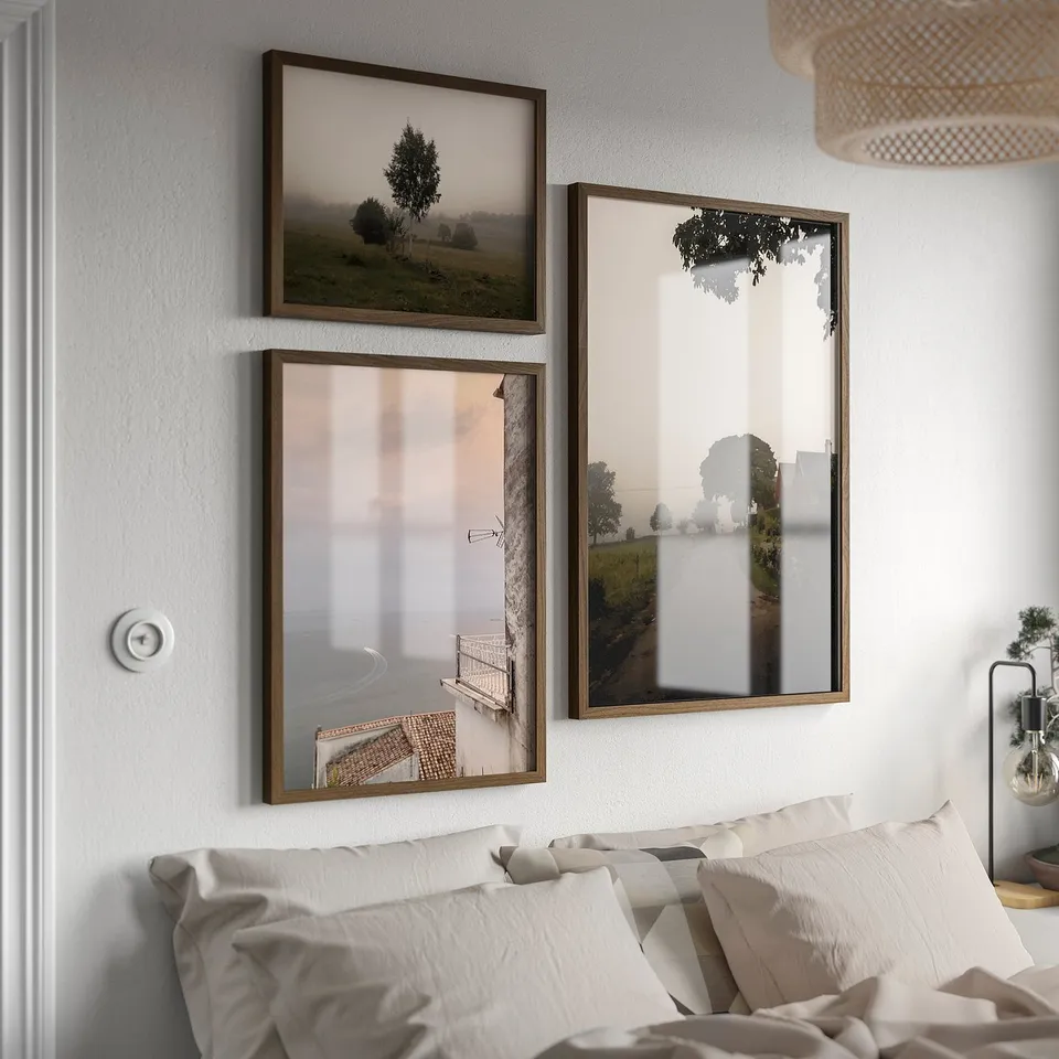 Three RÖDALM frames on wall above bed, showing landscapes, all brown, rectangular, different sizes.