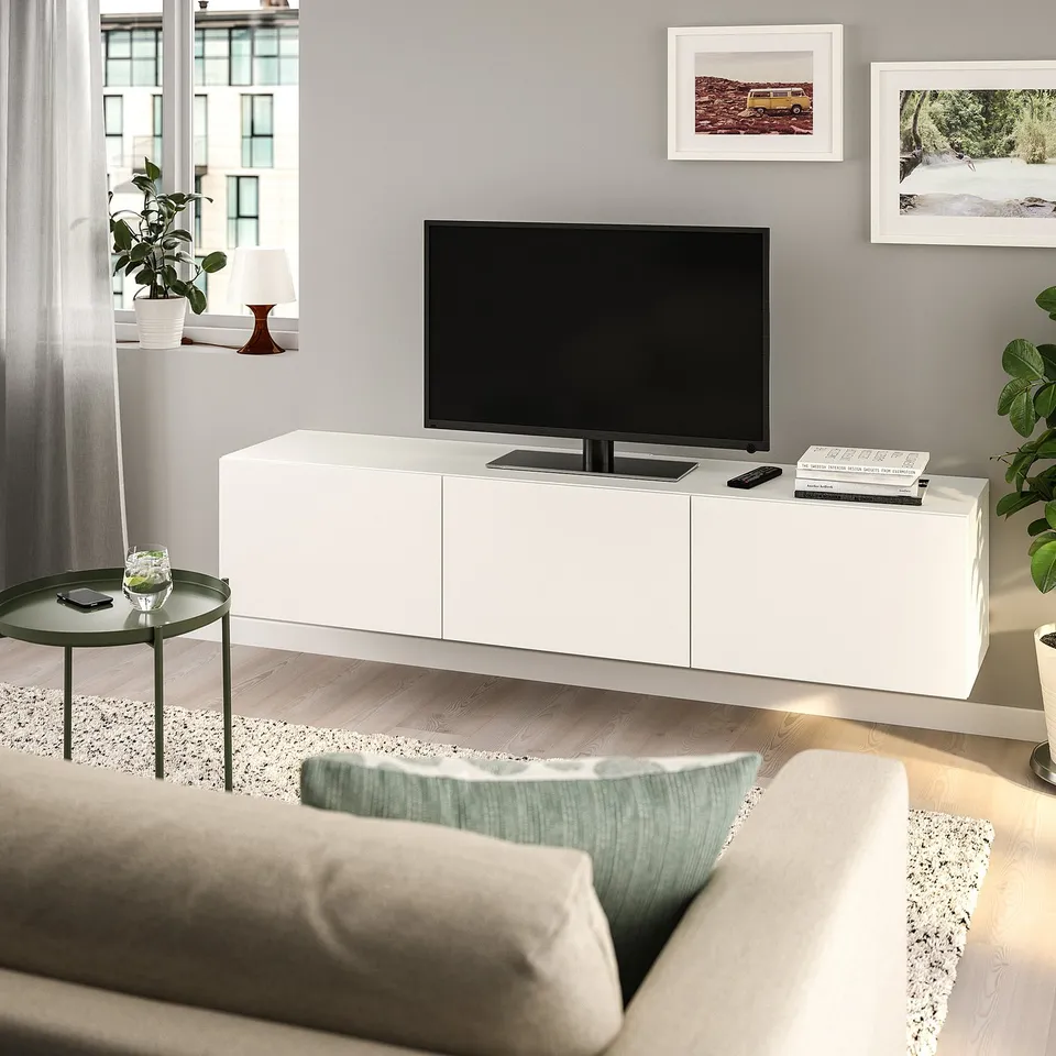 Modern living room with BESTÅ tv bench, flat screen, books, and soft decor.