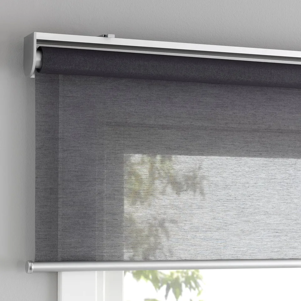 Roller blind partially covering window, letting in soft light, with cordless design for safety.