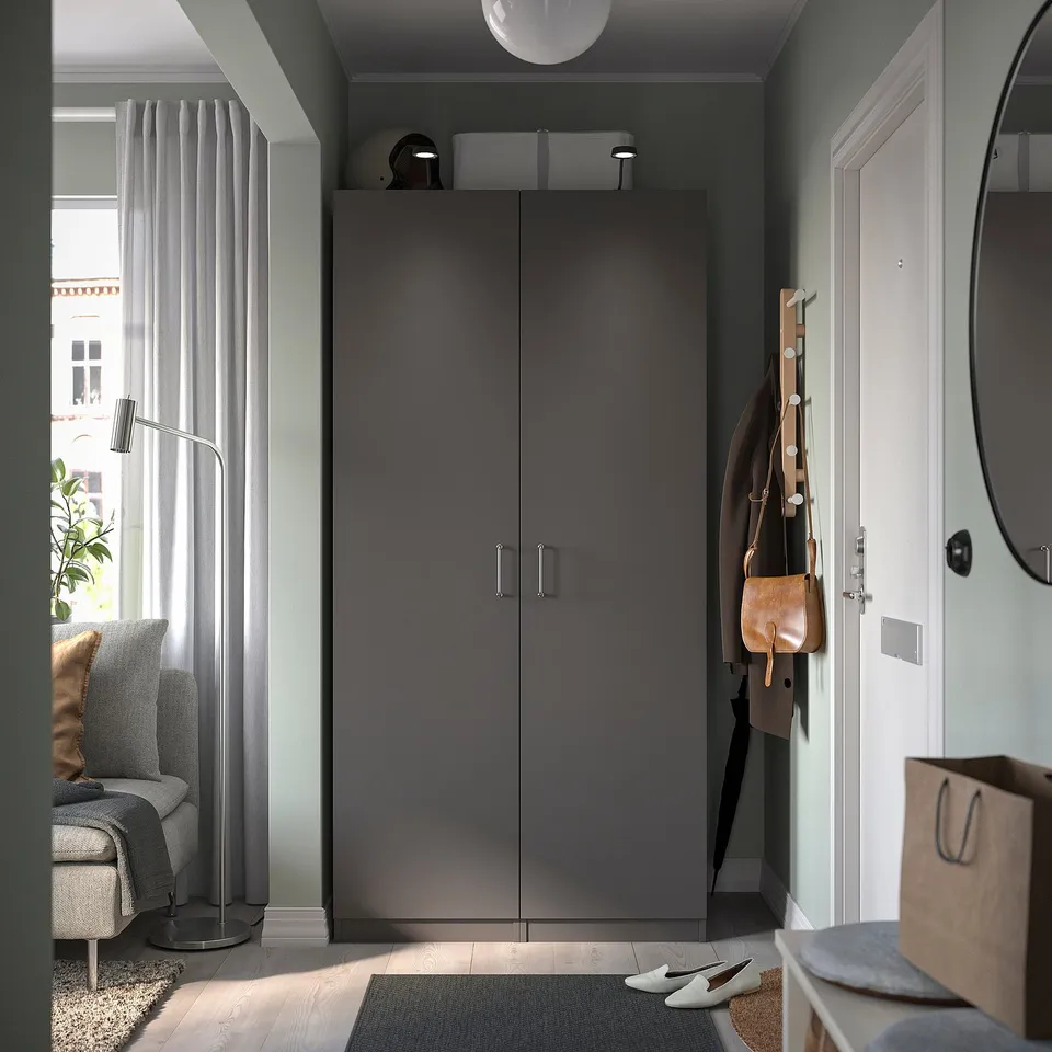 Modern, dark grey pax wardrobe with sleek, smooth doors and nickel-plated hinges, featuring a minimalist design.
