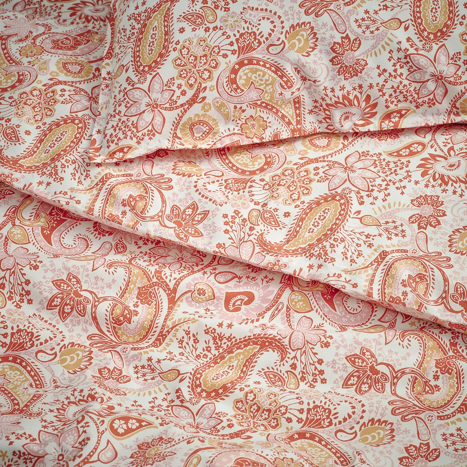 Paisley patterned duvet cover in shades of orange and beige, showcasing intricate designs and high-quality fabric texture.