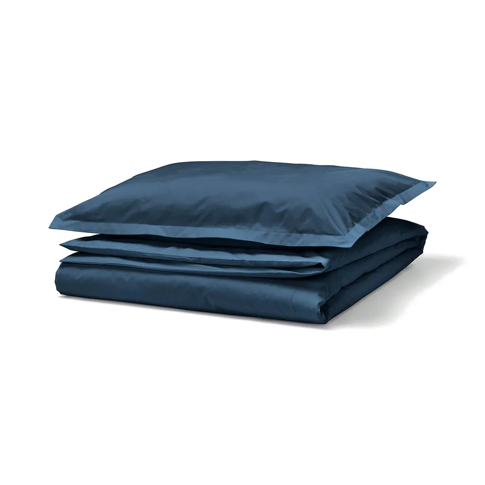 HAMPFLOCKEL dark blue bedding set of folded duvet and pillow. 100% cotton, crisp percale weave with button closure and flange detail.