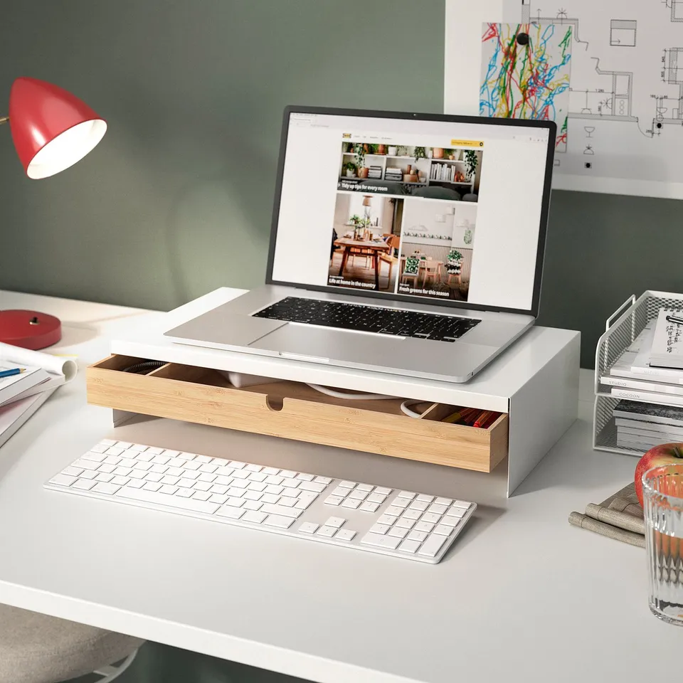 Modern workspace featuring MITTZON laptop stand in silver wood, keyboard, and red lamp on a white desk.