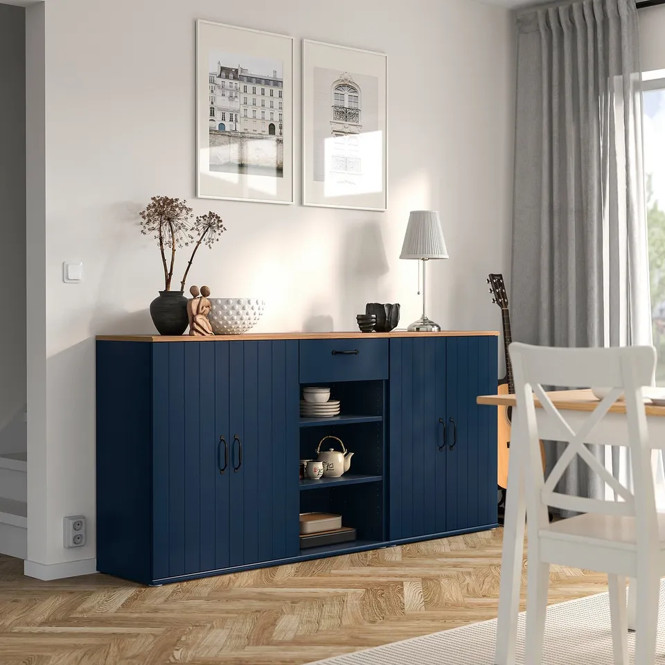 Blue SKRUVBY sideboard with shelves, two doors, white chair.