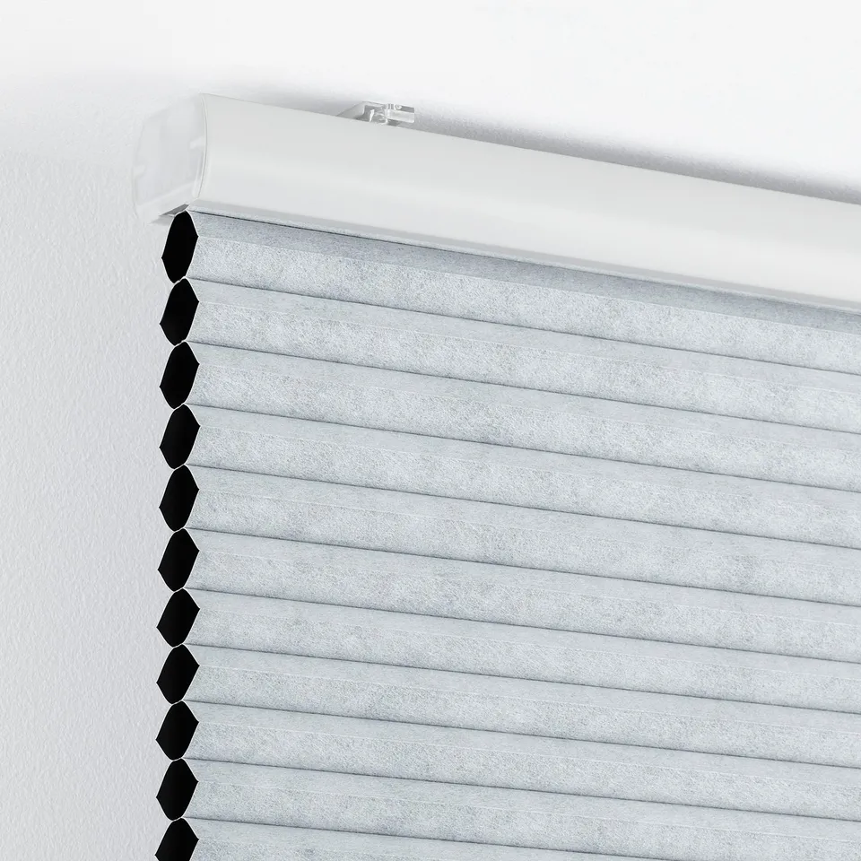 Close-up of closed trippavel block-out blinds, light grey, showing cordless light-blocking feature.